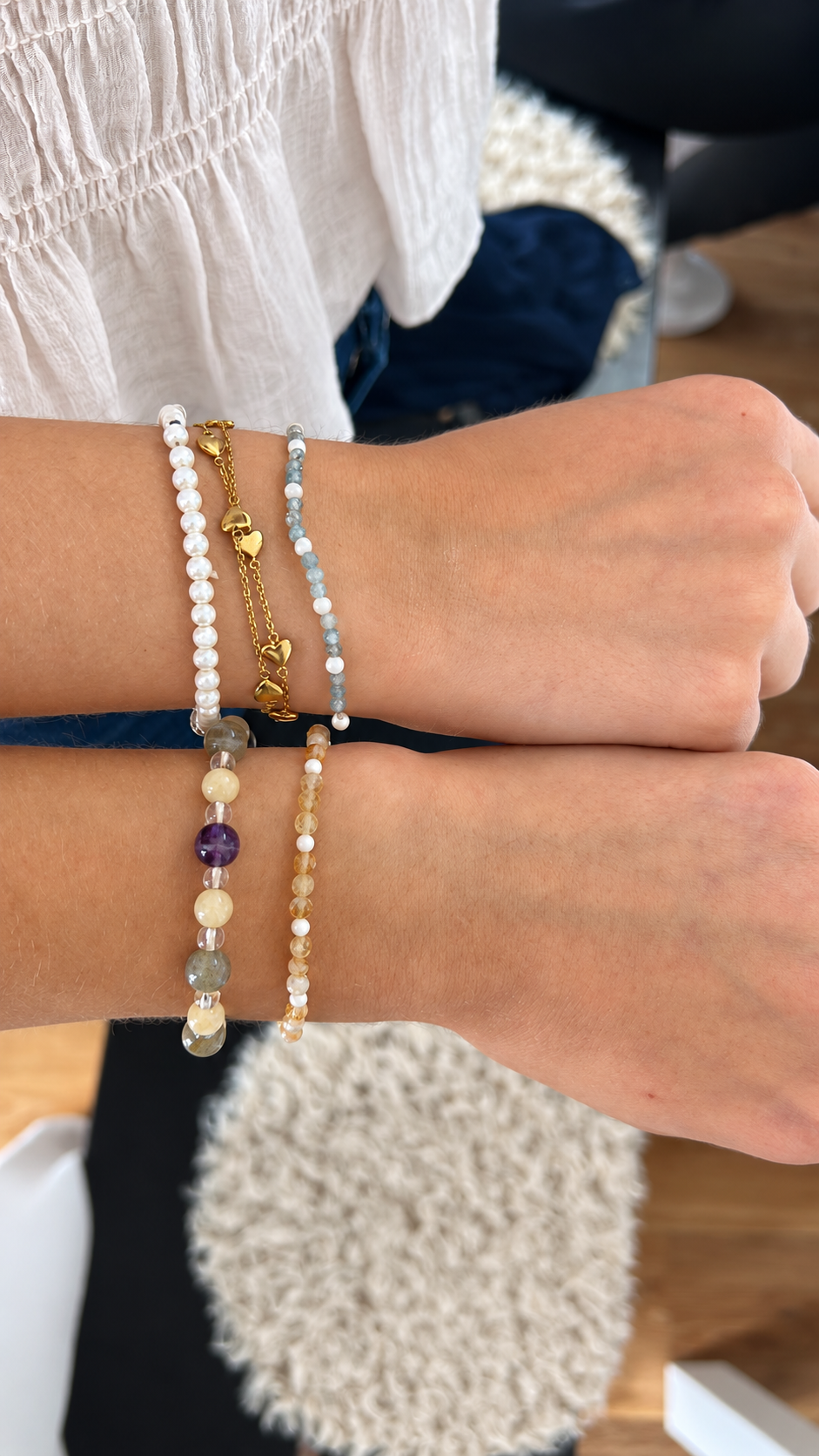 Zwei Hände mit Edelsteinarmbändern