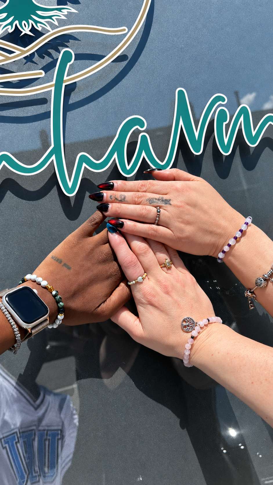 Hände mit individuellen Edelsteinarmbändern